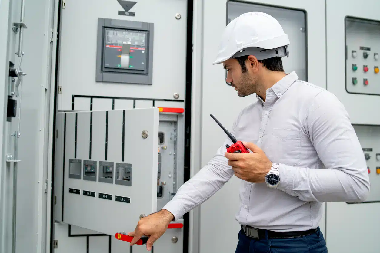 Different actions and working of engineer man hold walkie talkie and sometime use to contact his coworker and stay in front of electrical control panel. Retrofit Motor Control Buckets